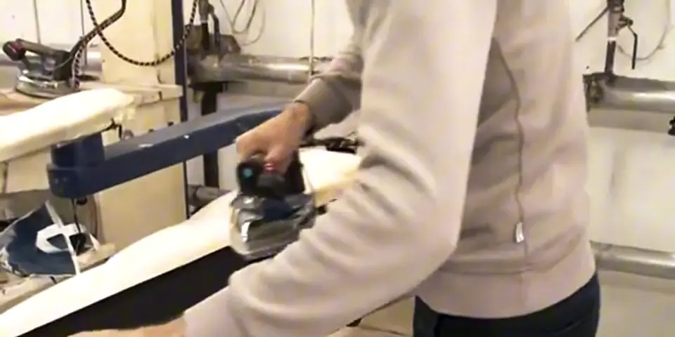 Pressing a garment on a vacuum ironing table
